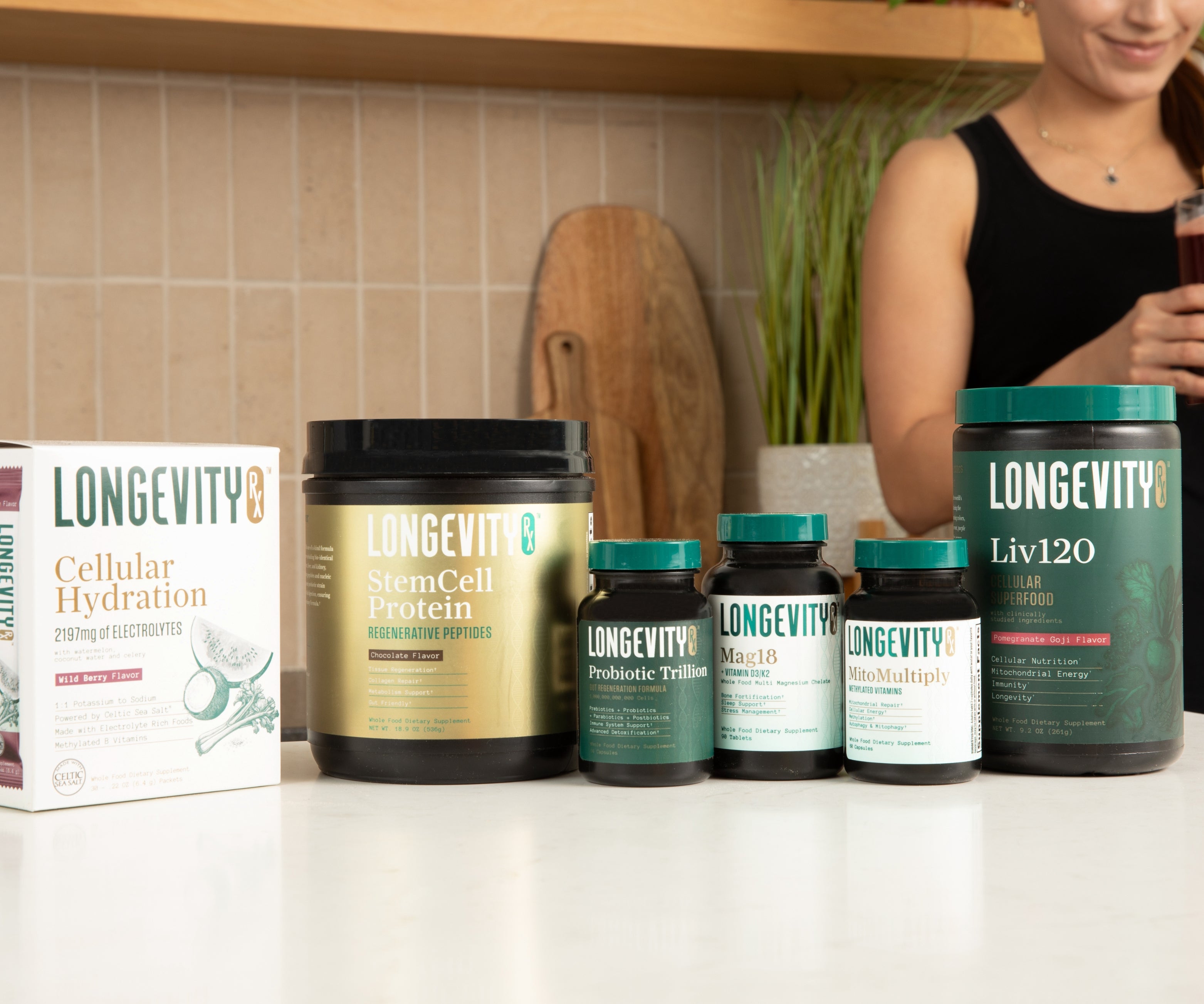 Collection of Longevity health products on a kitchen counter with a person in the background.