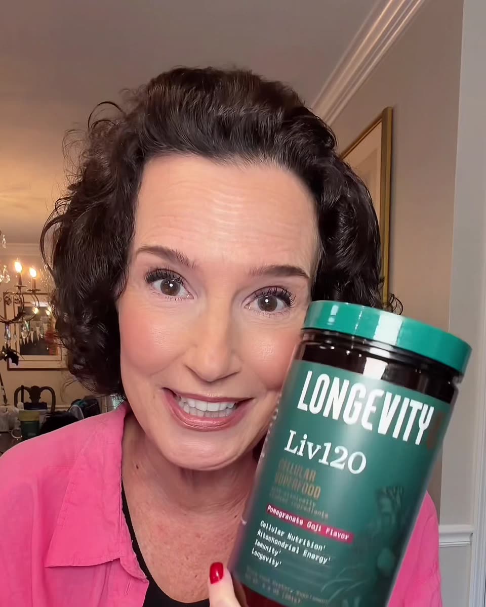 Kathy smiling and holding a jar of Liv120