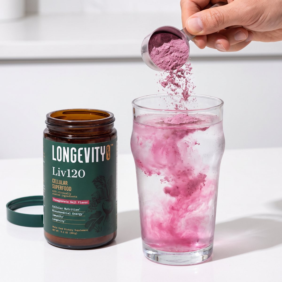 A scoop of Liv120 powder pouring into a glass of water and swirling pink
