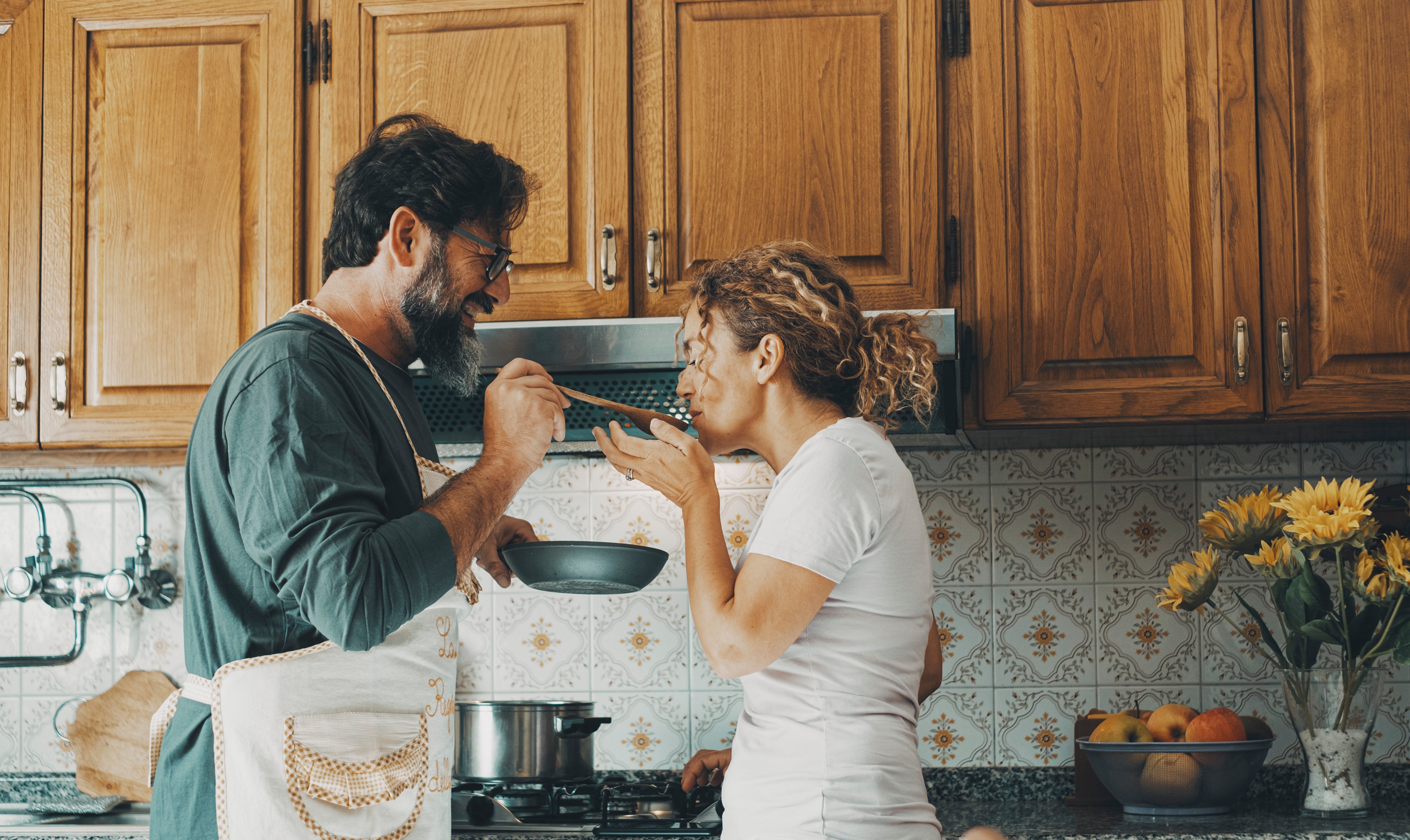 Couple tasting food together in their kitchen